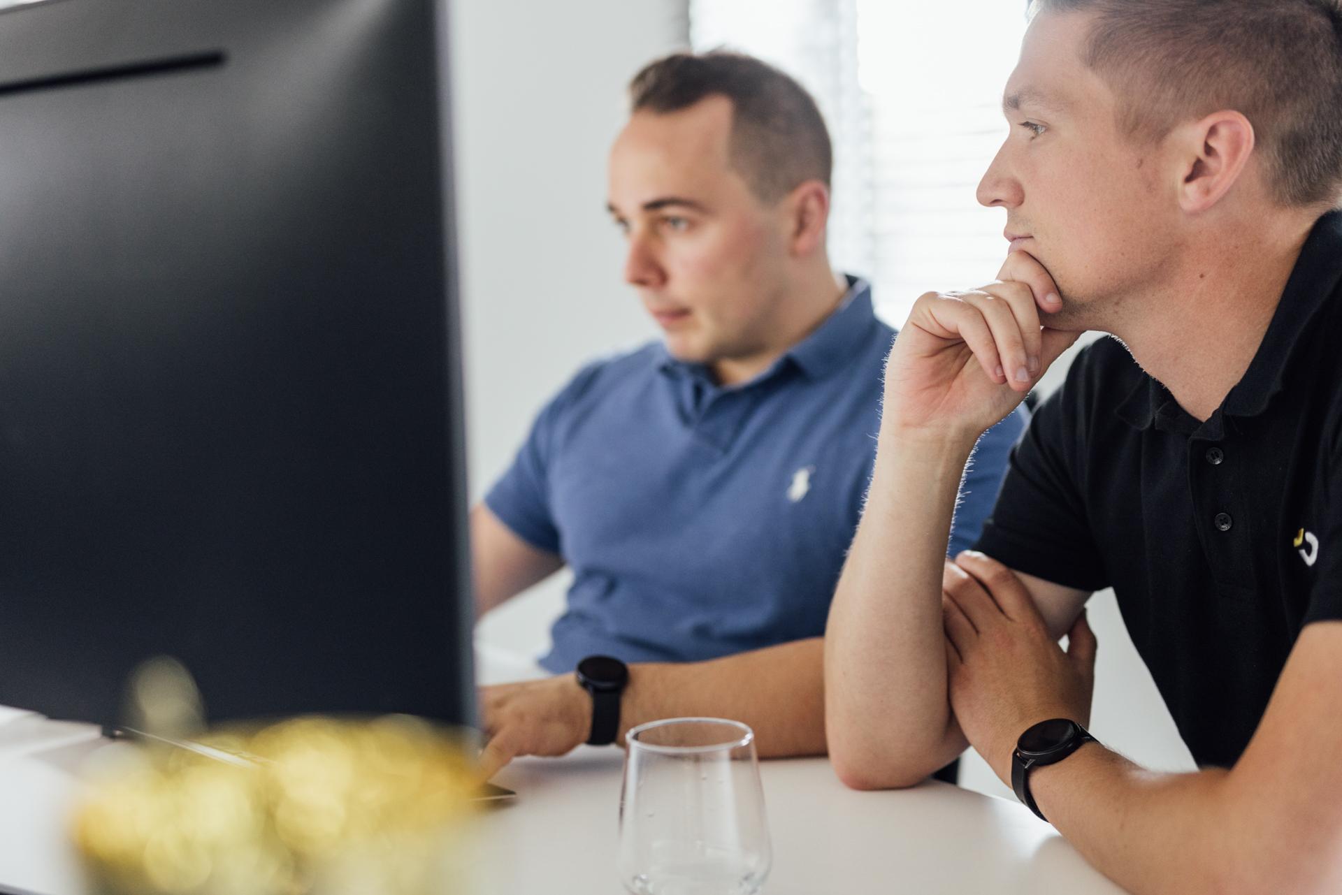 Twee collega's achter een scherm
