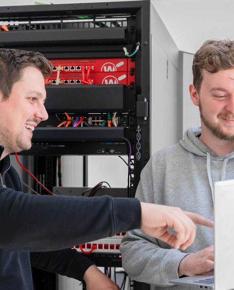 twee werknemers in overleg voor een serverrack