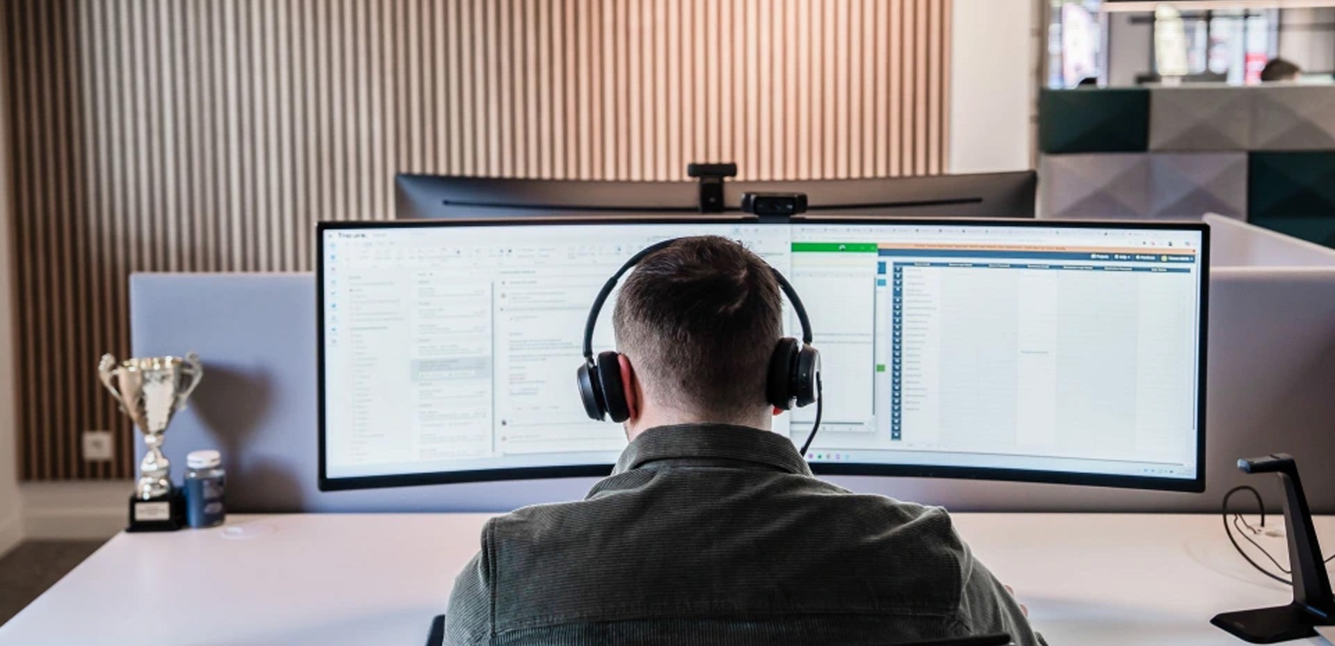 iemand die aan zijn scherm zit met een hoofdtelefoon op