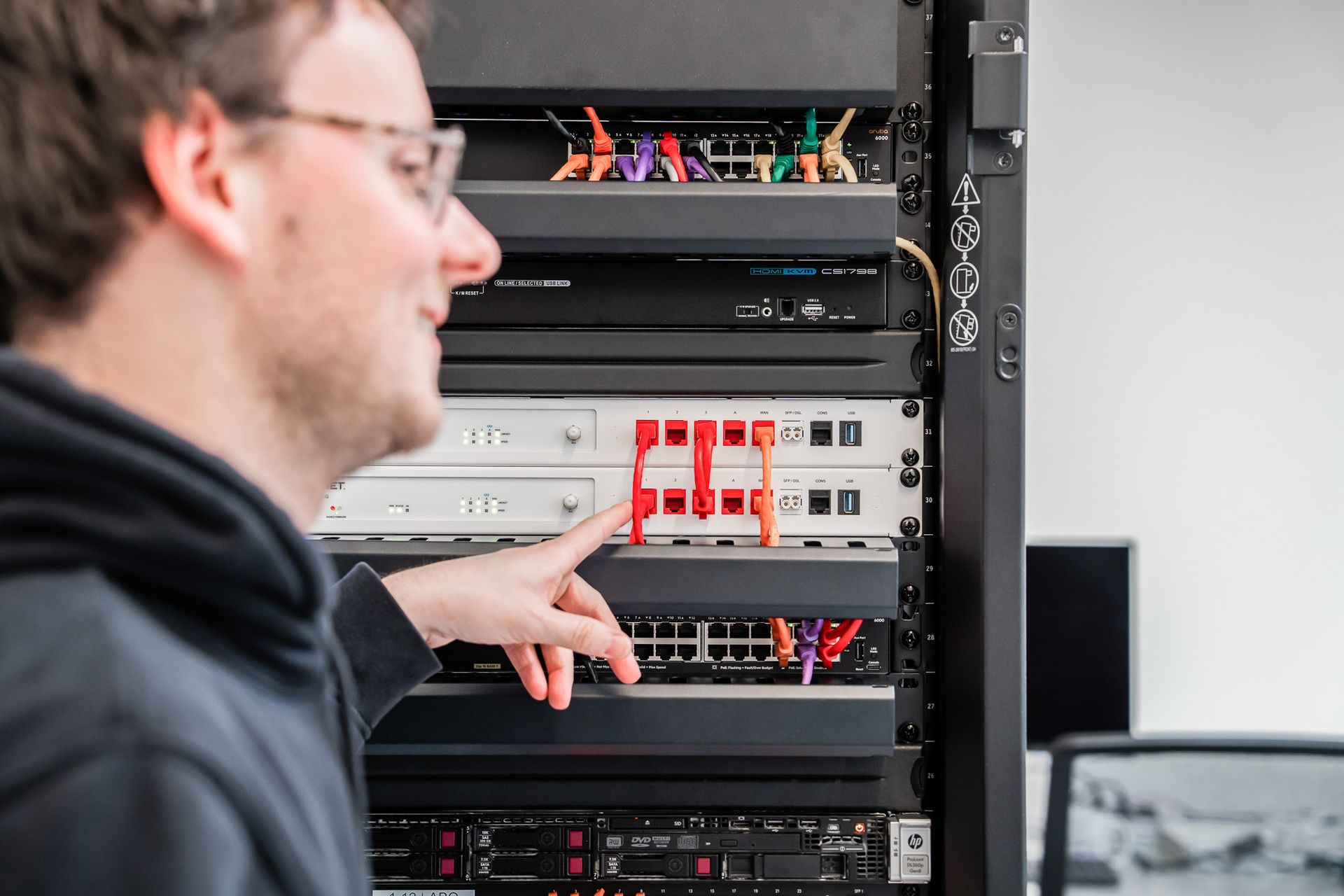 Collega die een firewall aanduidt in de serverrack